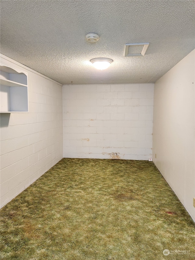 basement with dark colored carpet and a textured ceiling