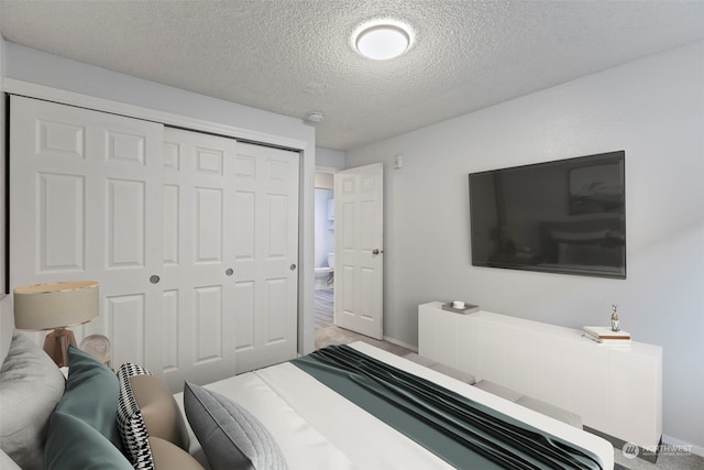 bedroom with carpet, a textured ceiling, and a closet