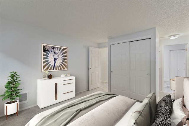 carpeted bedroom featuring a textured ceiling and a closet