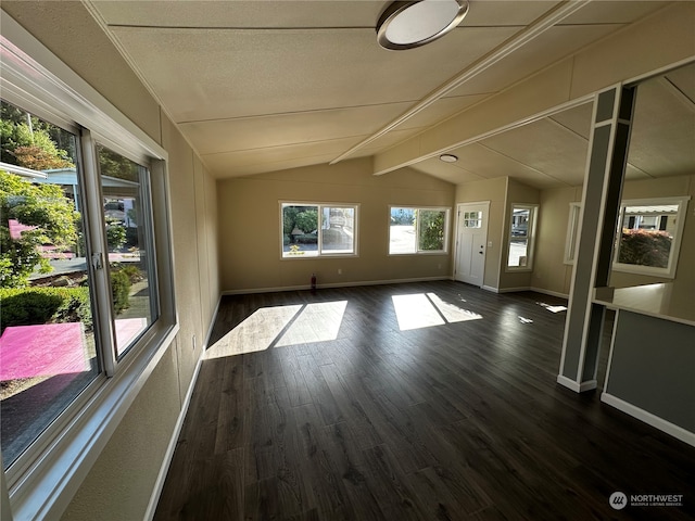 empty room featuring vaulted ceiling with beams and dark hardwood / wood-style flooring