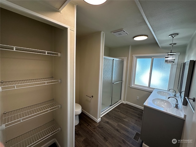 bathroom featuring vanity, toilet, hardwood / wood-style floors, and a shower with shower door