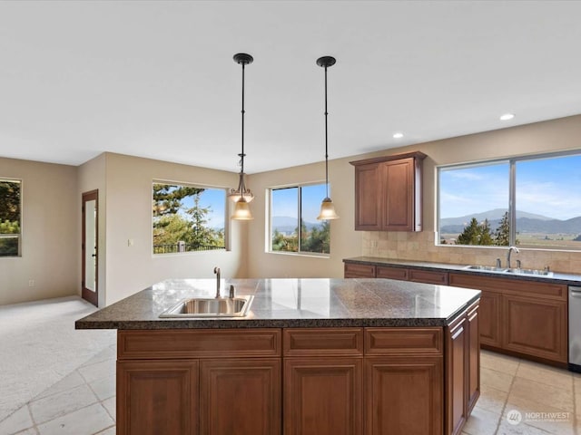 kitchen featuring a mountain view, sink, and a center island with sink