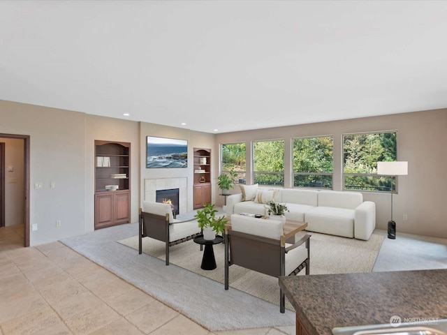 tiled living room featuring built in shelves and a tile fireplace