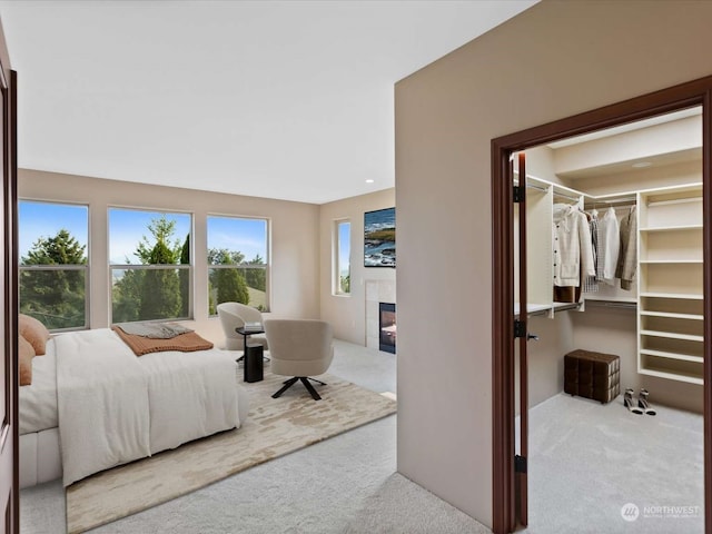 carpeted bedroom featuring a closet and a fireplace