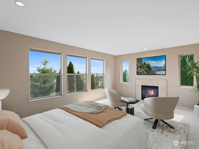 bedroom featuring a tile fireplace and carpet floors