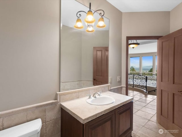 bathroom with vanity, toilet, an inviting chandelier, and tile patterned flooring