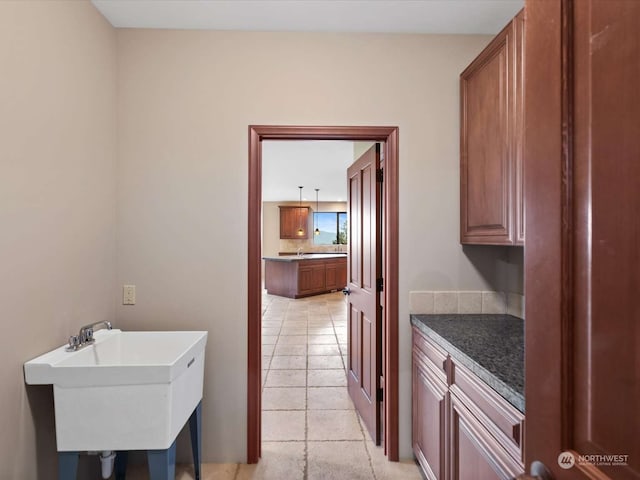 laundry room featuring sink and light tile patterned flooring