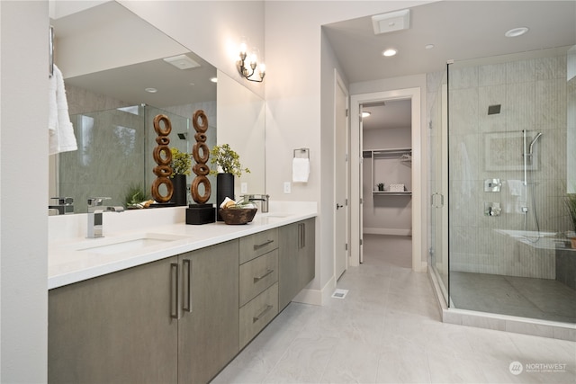 bathroom featuring vanity, a shower with shower door, and tile patterned flooring