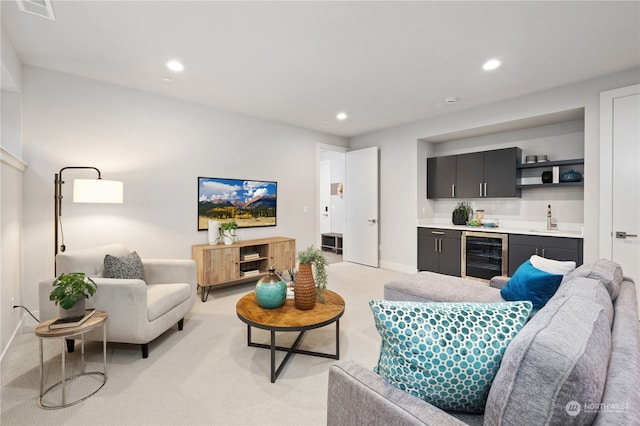 living room featuring beverage cooler, light colored carpet, and indoor wet bar