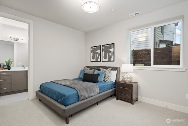 bedroom featuring light colored carpet and ensuite bath