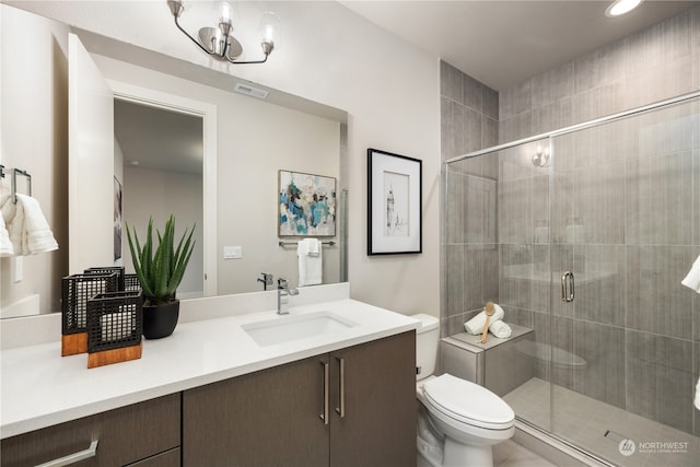 bathroom featuring vanity, toilet, a notable chandelier, and walk in shower