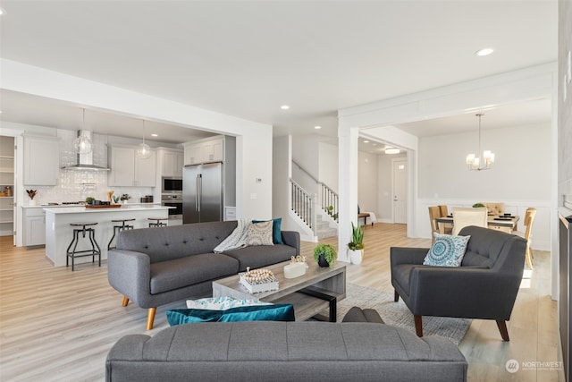 living room featuring an inviting chandelier and light hardwood / wood-style floors