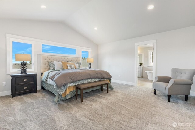 carpeted bedroom with vaulted ceiling and connected bathroom