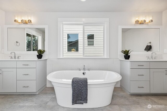 bathroom featuring vanity, tile walls, and a bathing tub