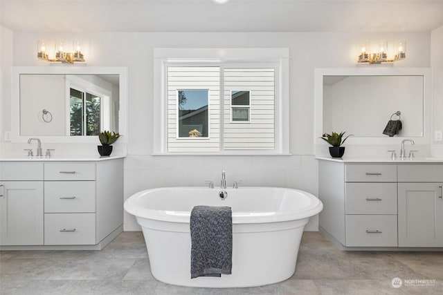 bathroom featuring tile walls, two vanities, and a sink