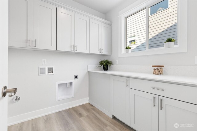 clothes washing area with hookup for a washing machine, cabinets, electric dryer hookup, and light hardwood / wood-style floors