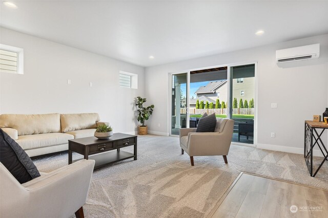 living room featuring plenty of natural light, light hardwood / wood-style flooring, and a wall mounted air conditioner