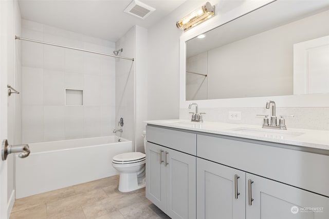 full bathroom featuring tiled shower / bath combo, vanity, and toilet