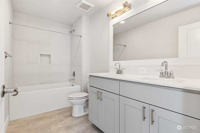 bathroom with a sink, visible vents, toilet, and double vanity