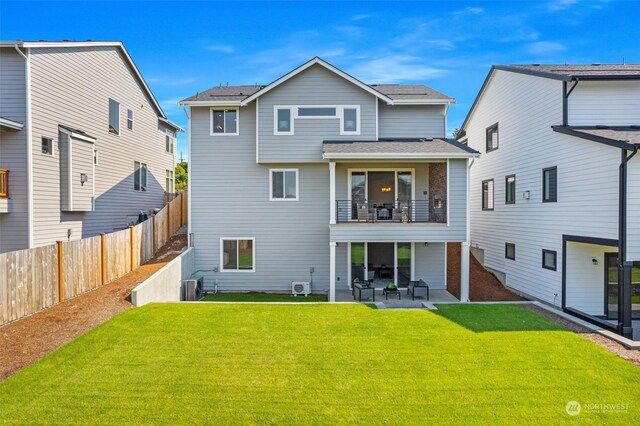 rear view of property with a balcony, a patio area, a lawn, and cooling unit