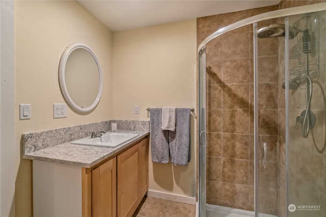 bathroom with tile patterned floors, walk in shower, and vanity