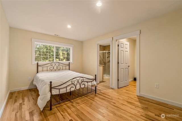 bedroom with ensuite bath and light hardwood / wood-style flooring