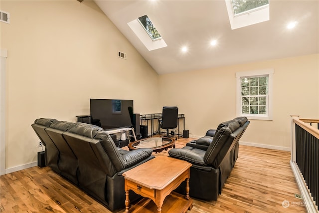 living room with light hardwood / wood-style flooring, a wealth of natural light, and high vaulted ceiling