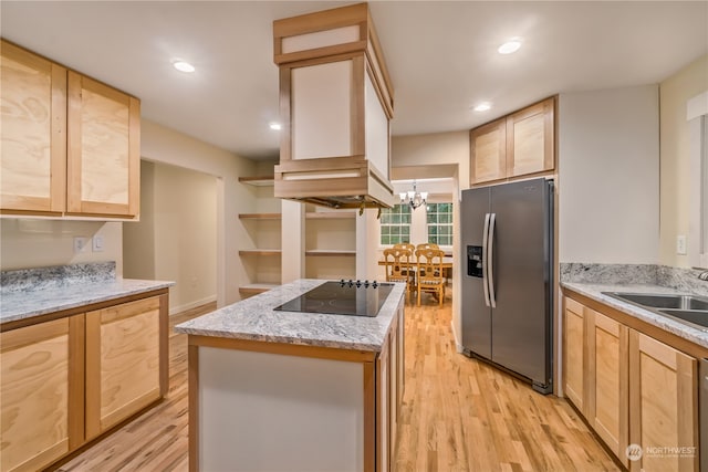 kitchen featuring stainless steel fridge, light brown cabinets, light hardwood / wood-style flooring, and a notable chandelier