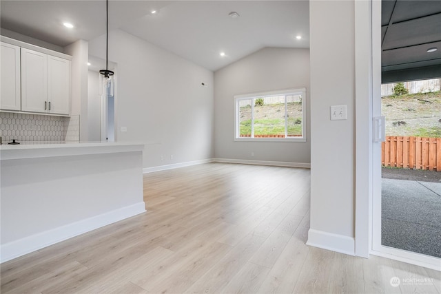 unfurnished living room with light hardwood / wood-style floors and lofted ceiling