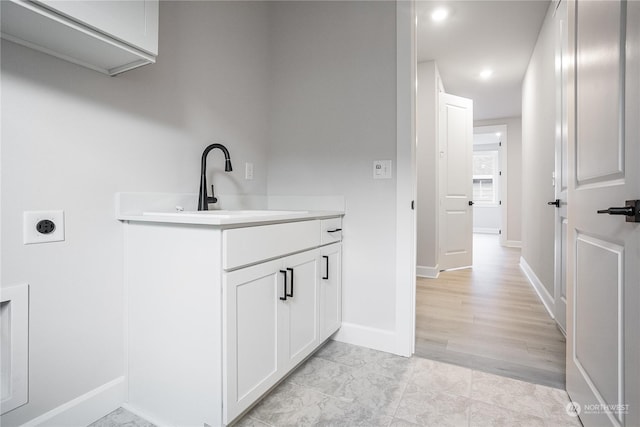 clothes washing area with electric dryer hookup and sink