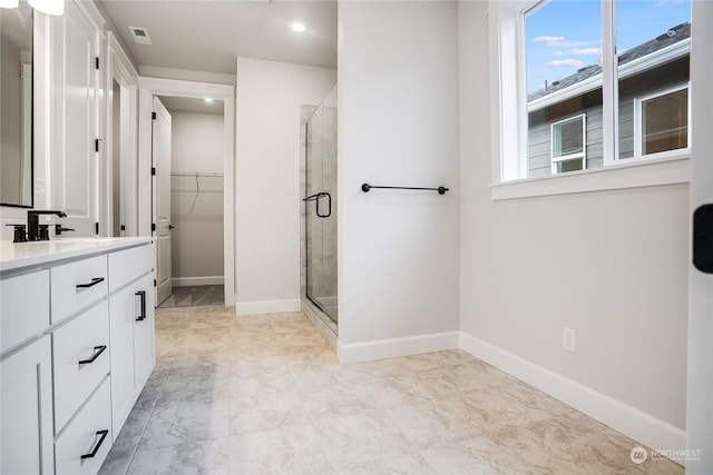 bathroom with a shower with door and vanity