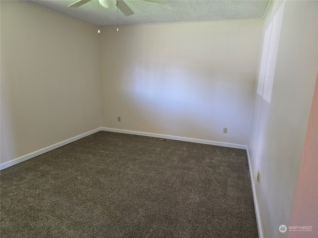 spare room with a textured ceiling, dark colored carpet, and ceiling fan