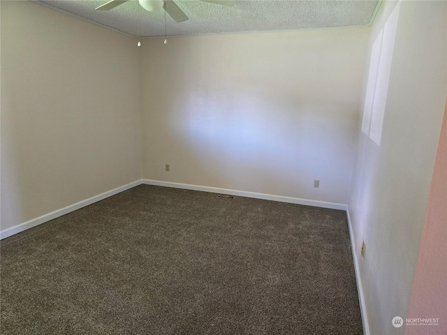 empty room with baseboards, a ceiling fan, dark colored carpet, and a textured ceiling