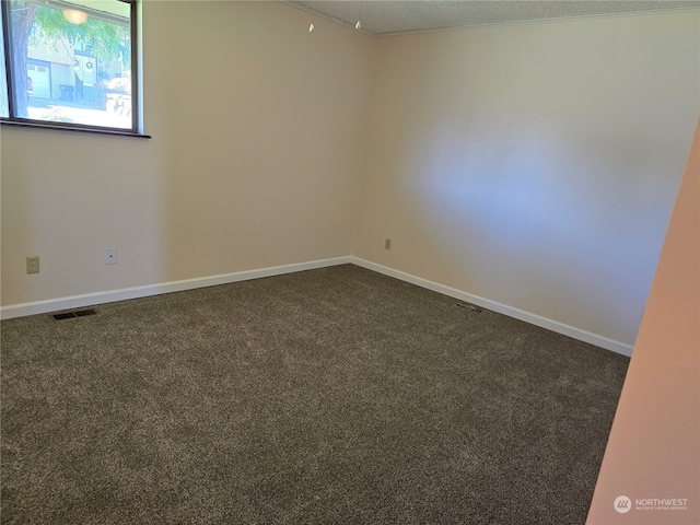 carpeted empty room featuring a textured ceiling