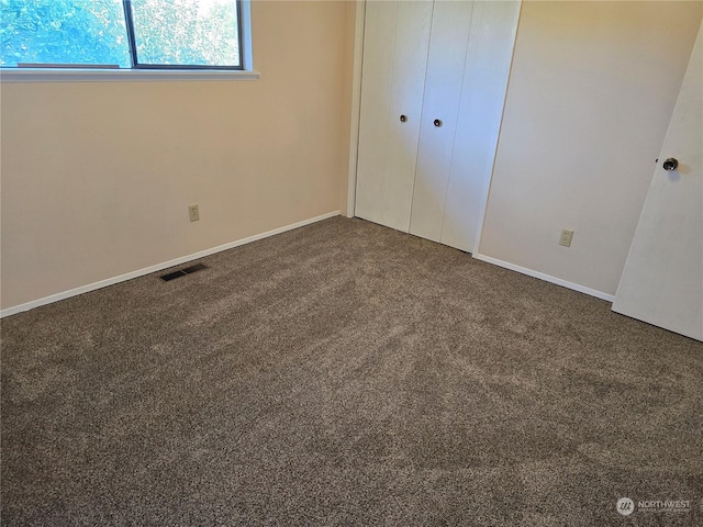 unfurnished bedroom featuring a closet, visible vents, baseboards, and carpet