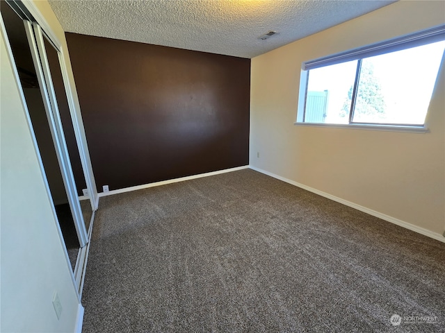 carpeted spare room featuring a textured ceiling