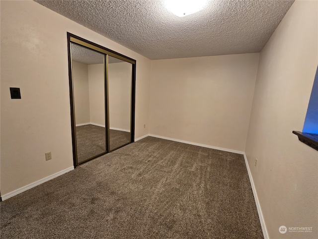 unfurnished bedroom with a textured ceiling, carpet, and a closet