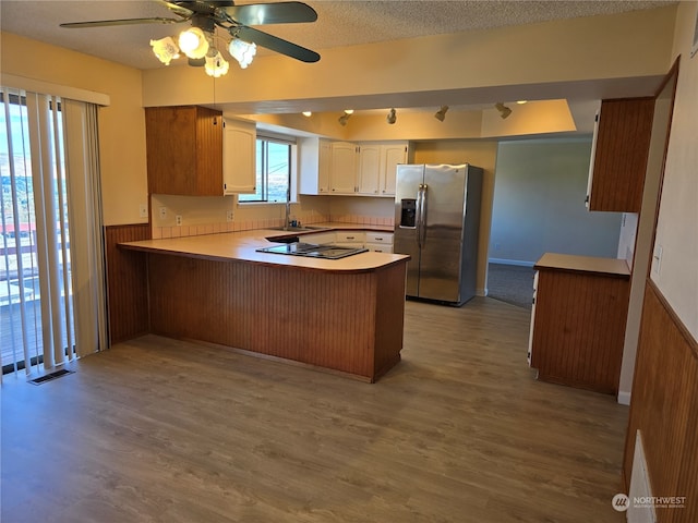 kitchen with white cabinets, light hardwood / wood-style flooring, kitchen peninsula, stainless steel refrigerator with ice dispenser, and ceiling fan