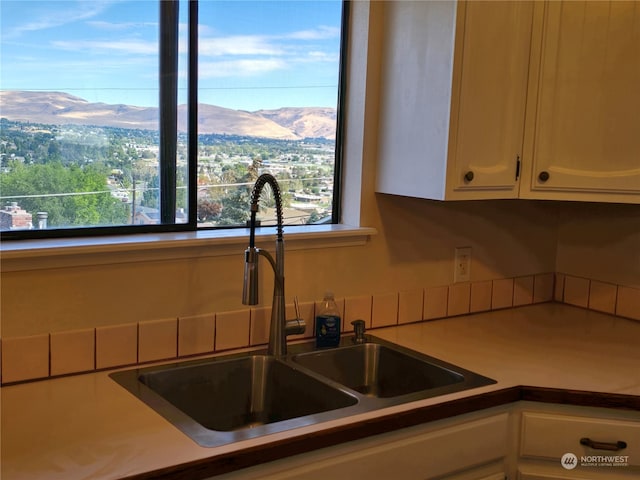 kitchen featuring a mountain view, sink, and white cabinets