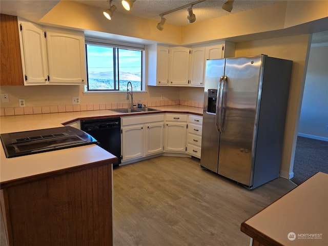 kitchen featuring stainless steel fridge, dishwasher, light hardwood / wood-style flooring, sink, and white cabinetry