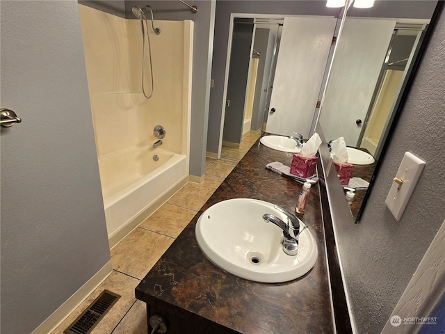 full bathroom with baseboards, visible vents, a sink, tile patterned flooring, and shower / washtub combination