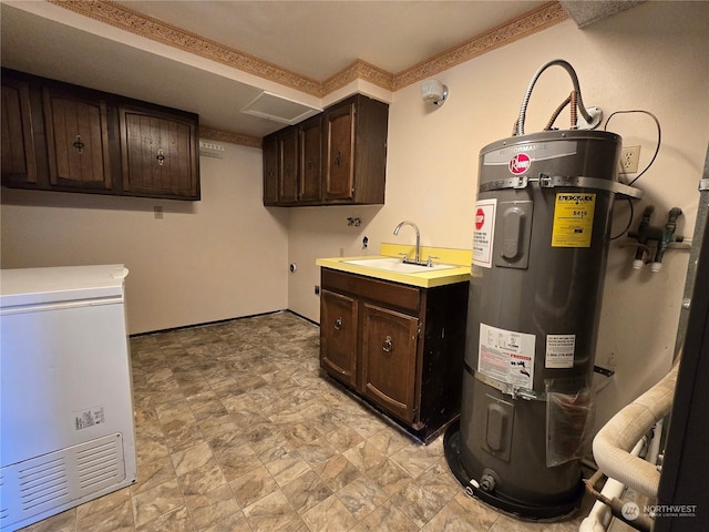 laundry room with cabinet space, electric water heater, and a sink