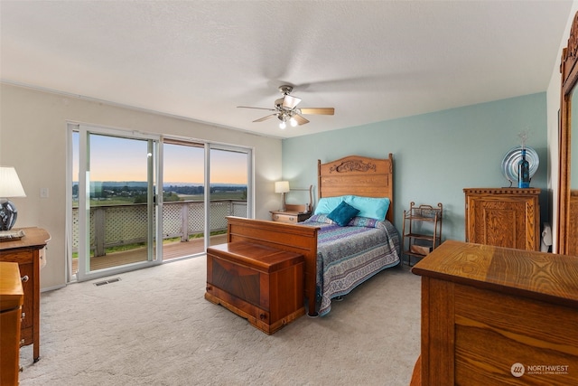 carpeted bedroom featuring ceiling fan, access to exterior, and a textured ceiling