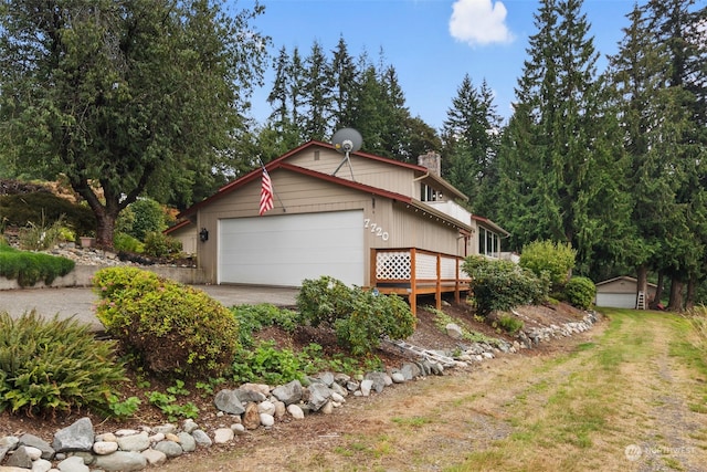 view of side of property featuring a wooden deck and a garage