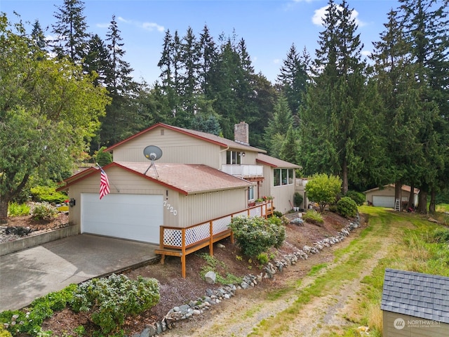 view of front of house with a garage and an outbuilding