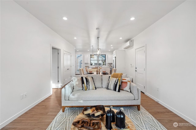 interior space with a wall mounted air conditioner and light hardwood / wood-style floors