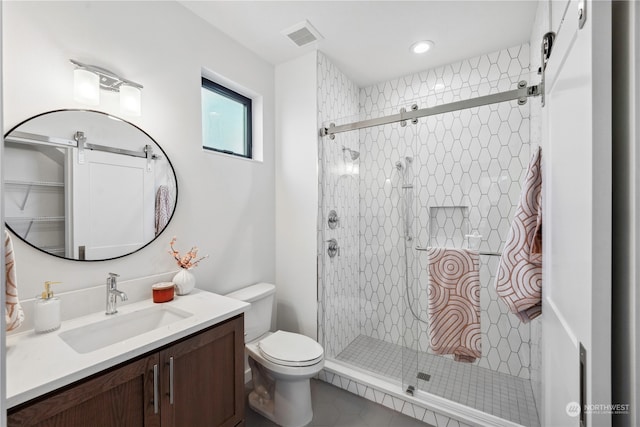 bathroom featuring tile patterned floors, vanity, toilet, and a shower with shower door