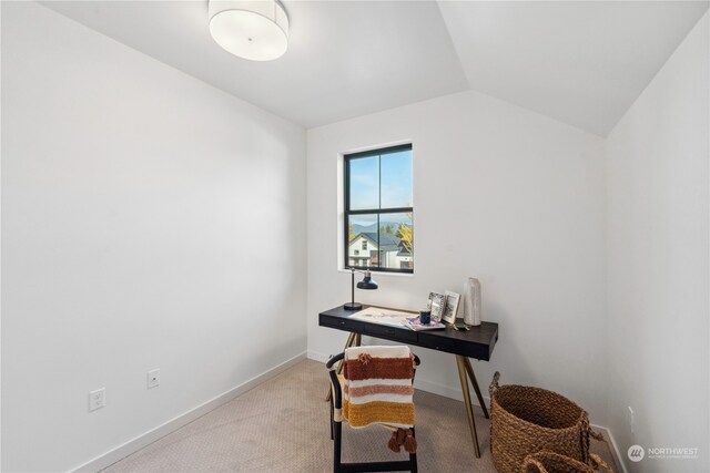 carpeted office space featuring vaulted ceiling