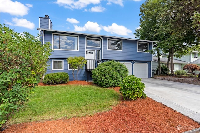 bi-level home featuring a garage and a front yard