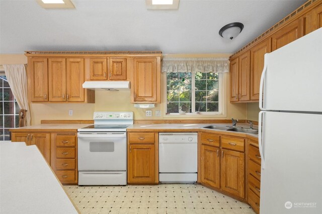 11 SE Fuchsia Ave, Shelton, WA 98584 - kitchen featuring white appliances, a sink, under cabinet range hood, light countertops, and brown cabinets